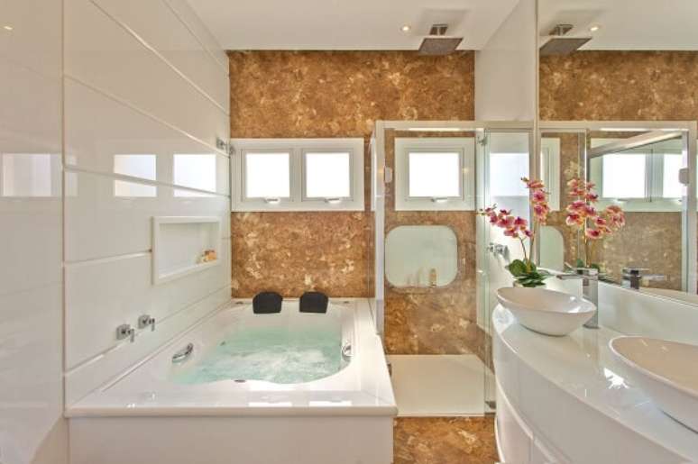 34. Banheiro com banheira e chuveiro cromado quadrado. Projeto por Iara Kilaris