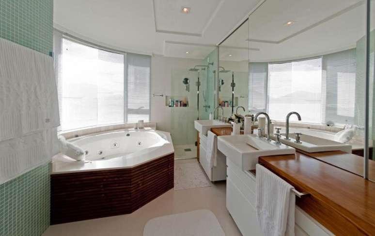 31. Banheiro com hidromassagem e área de banho com chuveiro cromado quadrado. Projeto por Juliana Pippi