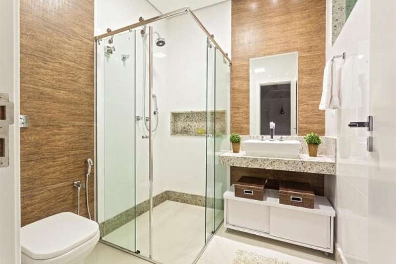 30. Banheiro com lavabo de granito e chuveiro elétrico cromado. Projeto por Laura Santos