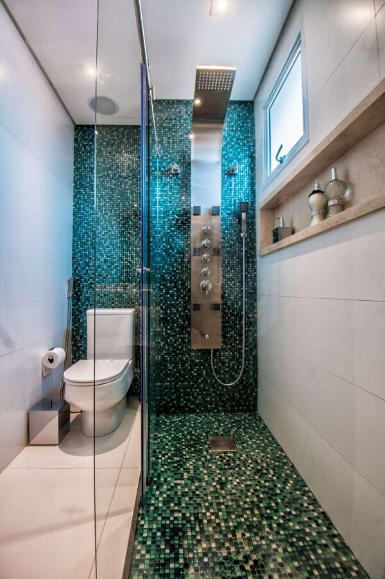 7. Banheiro com pastilhas de vidro e chuveiro cromado deslumbrante. Projeto por Giovana Pellegrini