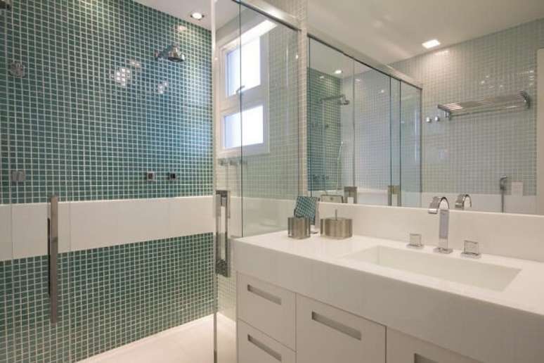 28. Banheiro com revestimento de pastilha verde e chuveiro elétrico cromado. Projeto por Marília Veiga Interiores