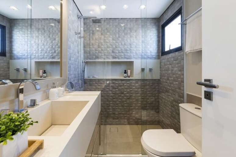 14. Parede com textura 3D e chuveiro cromado quadrado decoram o ambiente. Projeto por L&iacute;via Cavalca