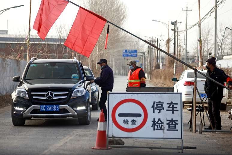 Voluntários param carro em posto de controle em estrada que leva para o vilarejo onde moram nos arredores de Pequim
12/01/2021 REUTERS/Thomas Peter