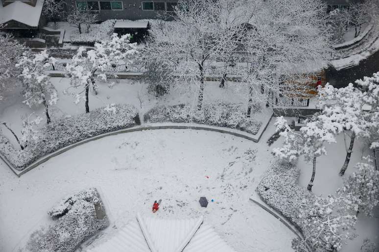 Menino tenta pegar neve que cai em Seul, Coreia do Sul
 12/1/ 2021.    REUTERS/Kim Hong-Ji