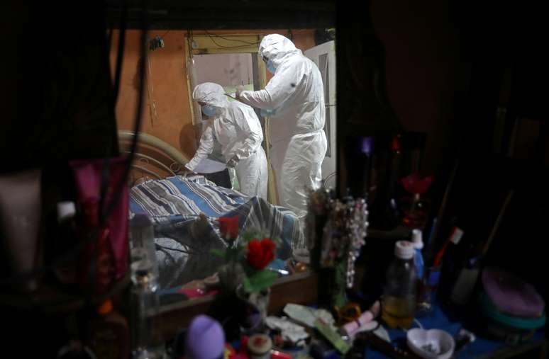 Profissionais de saúde examinam corpo de Shirlene Morais, que morreu em casa após apresentar sintomas de Covid-19
11/01/2021
REUTERS/Bruno Kelly