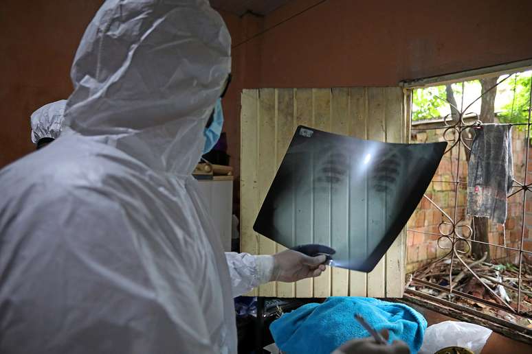 Funcionário municipal examina raio X de paciente que morreu de Covid-19 em casa, em Manaus, Amazonas
11/1/2021 REUTERS/Bruno Kelly