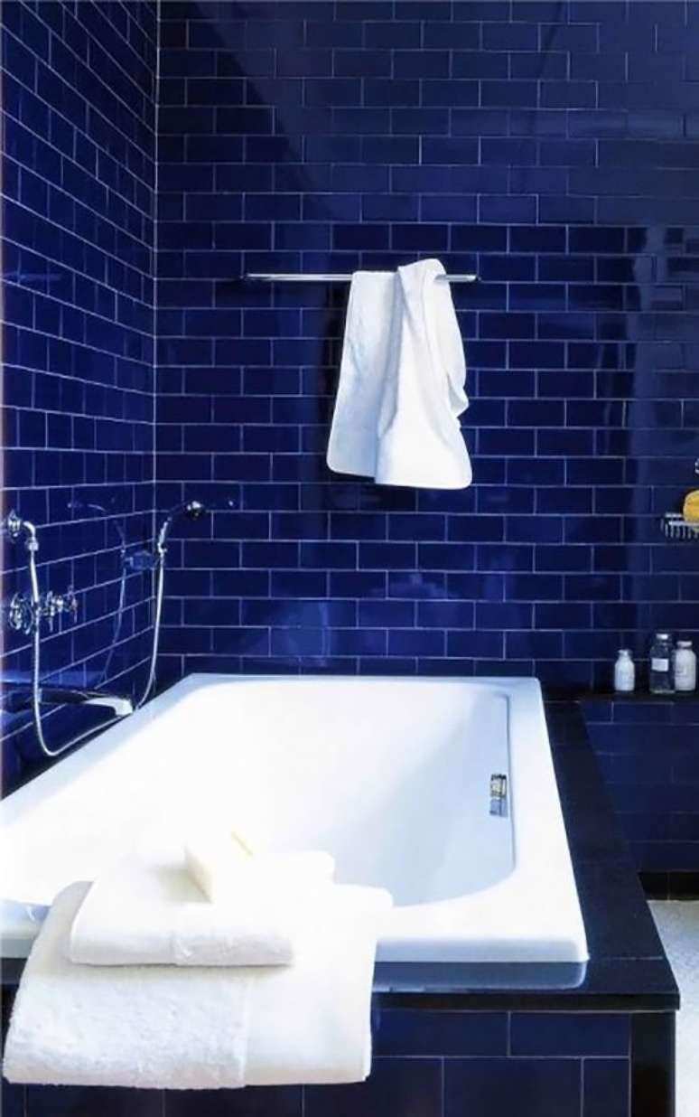 32. Banheiro com revestimento azul marinho e banheira branca – Via: Pinterest