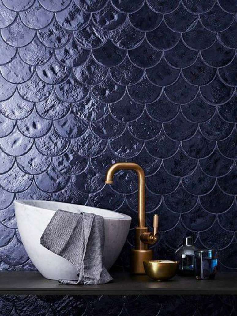 50. Banheiro em revestimento azul marinho com torneira dourado – Via: Micasa Revista