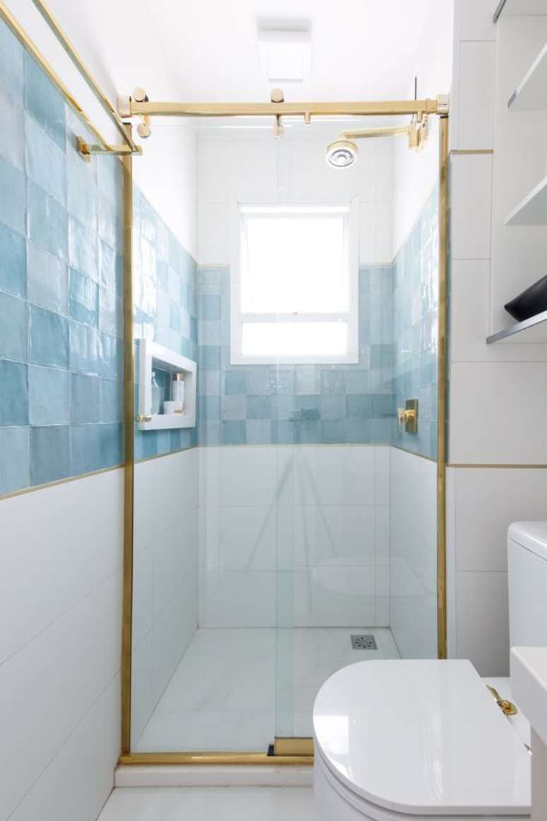 30. Revestimento azul no banheiro branco e dourado – Via: Espaço Projeto
