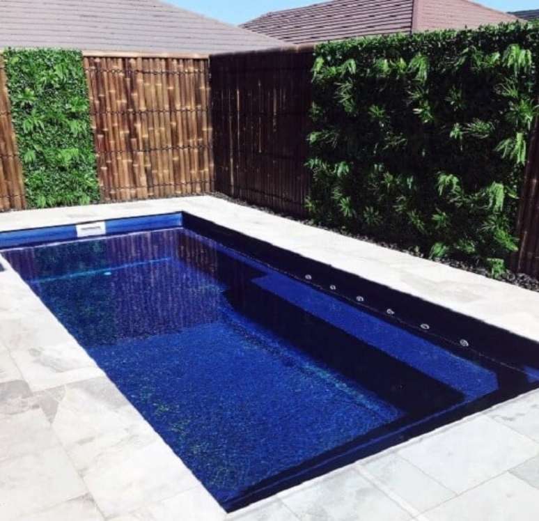 77. O jardim vertical e a cerca de bambu encantam a decora&ccedil;&atilde;o da piscina. Fonte: Pinterest