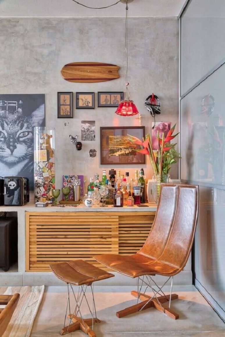42. Poltrona de couro moderna para sala decorada com parede de cimento queimado – Foto: Casa de Valentina