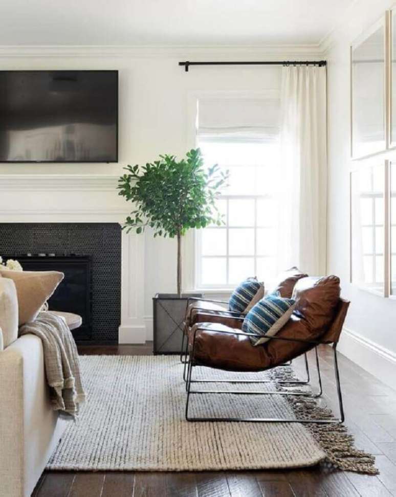 43. Decoração em cores claras para sala com lareira e poltrona de couro moderna – Foto: McGee & Co.