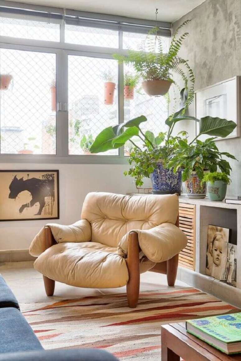 54. Poltrona de couro bege confortável para sala de estar com tapete colorido – Foto: Casa de Valentina