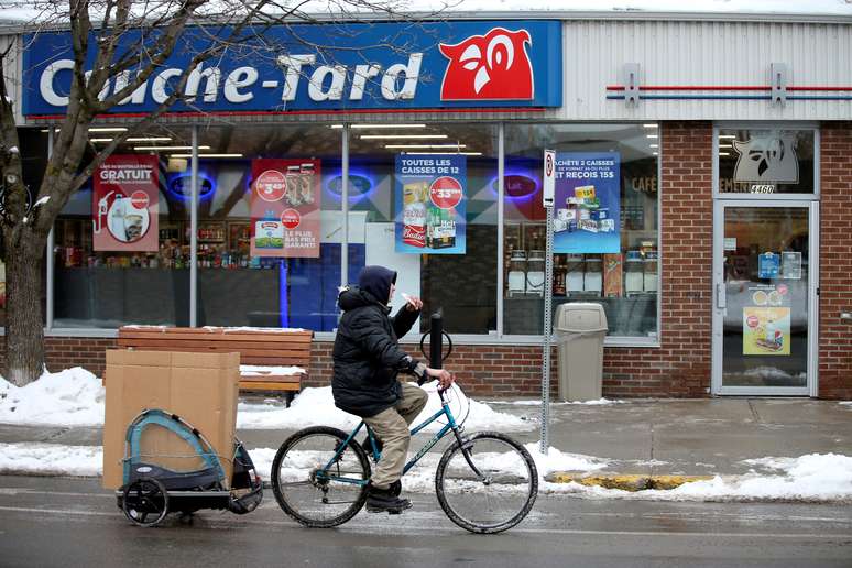 Homem de bicicleta passa em frent a loja de conveni&ecirc;ncia da Couche-Tard, no Canad&aacute;. 13/1/2021.  REUTERS/Christinne Muschi