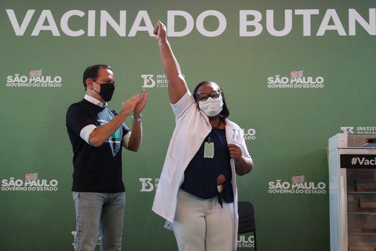 Enfermeira Mônica Calazans, 54, comemora após receber vacina contra Covid-19, ao lado do governador de SP, João Doria, no Hospital das Clínicas
 17/1/2021 REUTERS/Amanda Perobelli