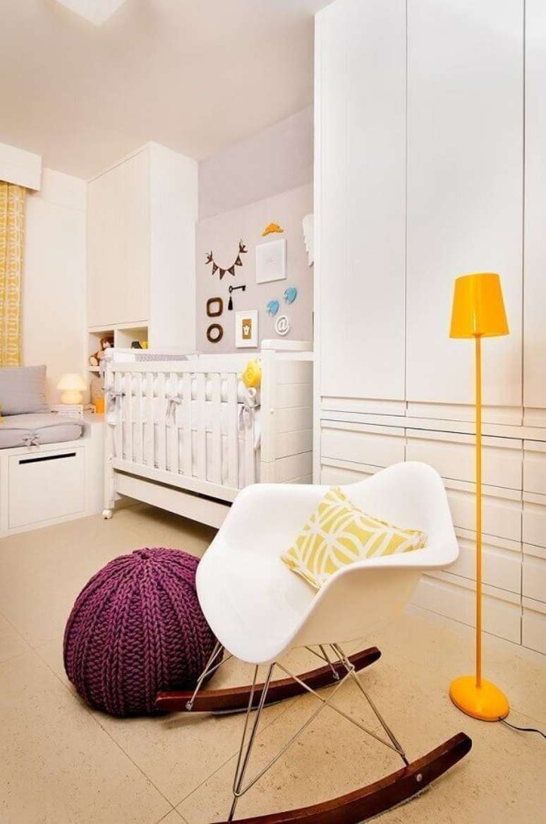 25. Decoração de quarto de bebê branco e cinza com luminária de chão amarela e puff colorido para cadeira de balanço branca – Foto: Pinterest