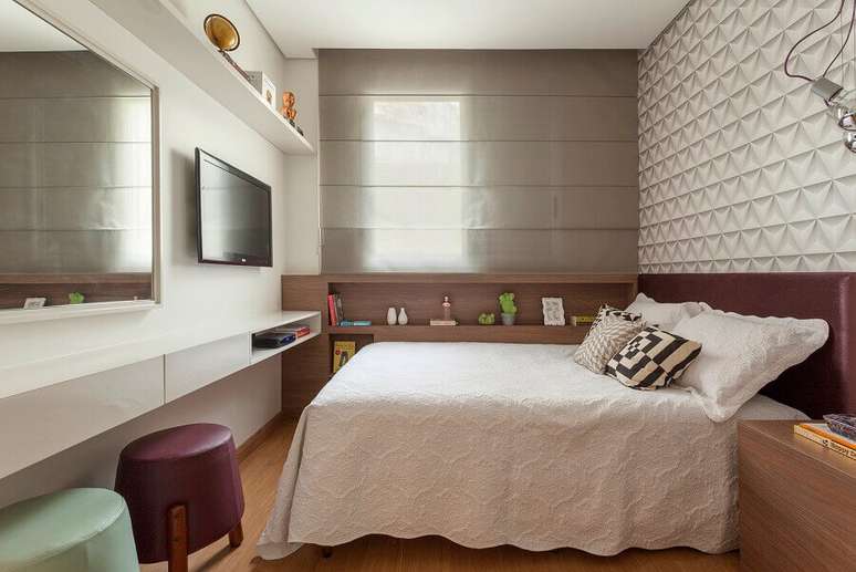 27. Decoração com puff colorido para quarto de casal planejado com papel de parede 3D – Foto: AMIS Arquitetura & Design