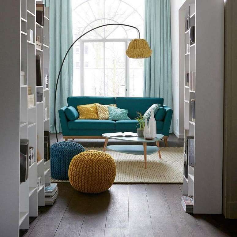 31. Puff colorido para sala de estar decorada com sofá retrô e tapete de crochê bege – Foto:
