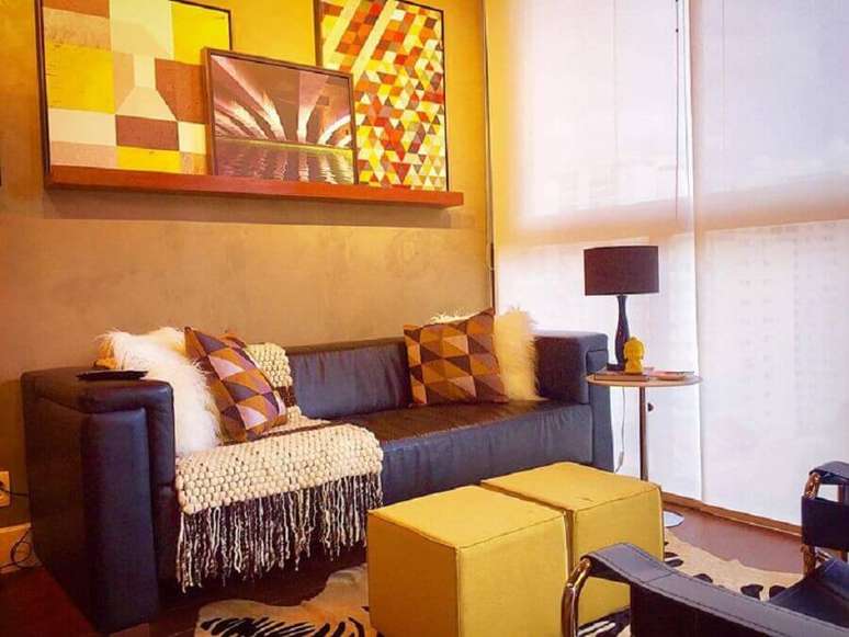 38. Puff quadrado colorido para sala de estar decorada com quadros abstratos e sofá marrom escuro – Foto: Andreas Móveis