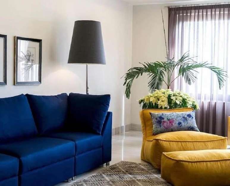 41. Decoração de sala de estar com puffo fofão colorido e sofá azul escuro – Foto: Pinterest