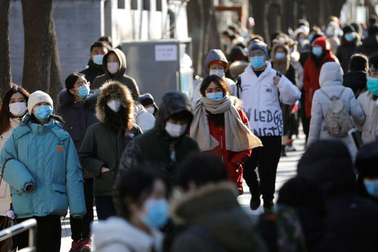 Pessoas andam de máscara em rua de Pequim . REUTERS/Tingshu Wang