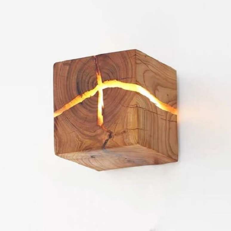 16. Arandela de madeira rústica com ranhuras que permitem a passagem da luz. Fonte: Pinterest