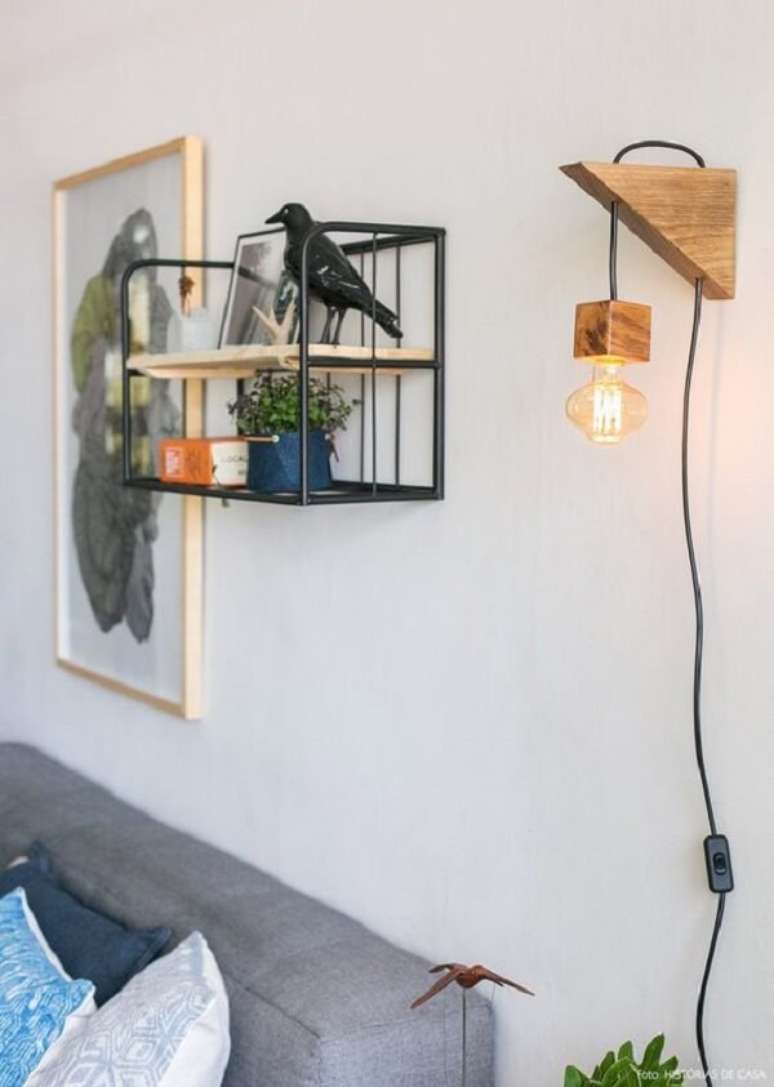 4. Arandela rústica de madeira traz um ponto de luz para a sala de estar. Fonte: História de Casa