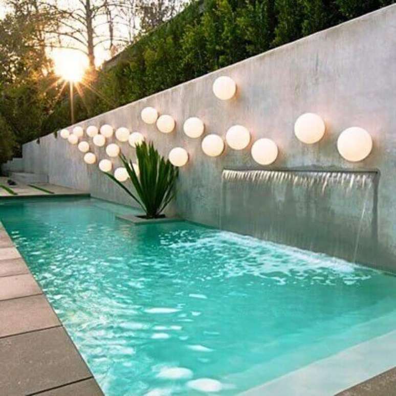 70- A cascata de piscina foi embutida no muro e tem varias luminárias completando a decoração. Fonte: Pinterest