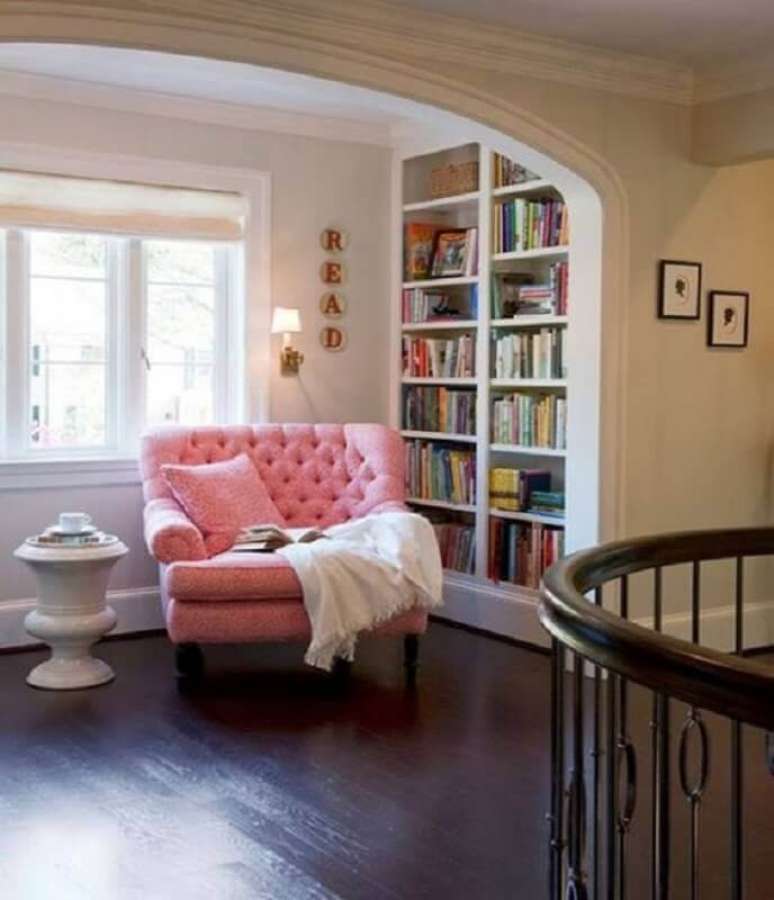 15. Decoração de cantinho de leitura planejado com estante para livros e poltrona confortável para leitura cor de rosa – Foto: Pinterest