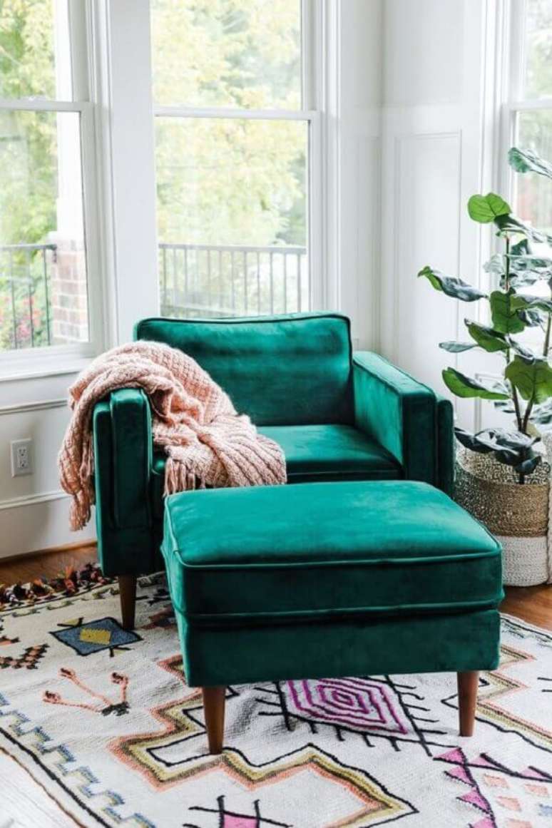 19. Cantinho de leitura decorado com tapete colorido e poltrona para leitura verde com puff – Foto: Edloe Finch