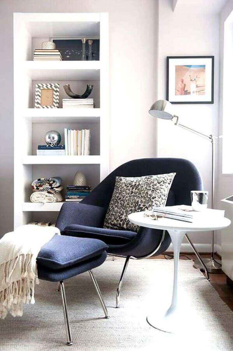 38. Decoração clean com poltrona para leitura moderna em azul escuro – Foto: Jeito de Casa