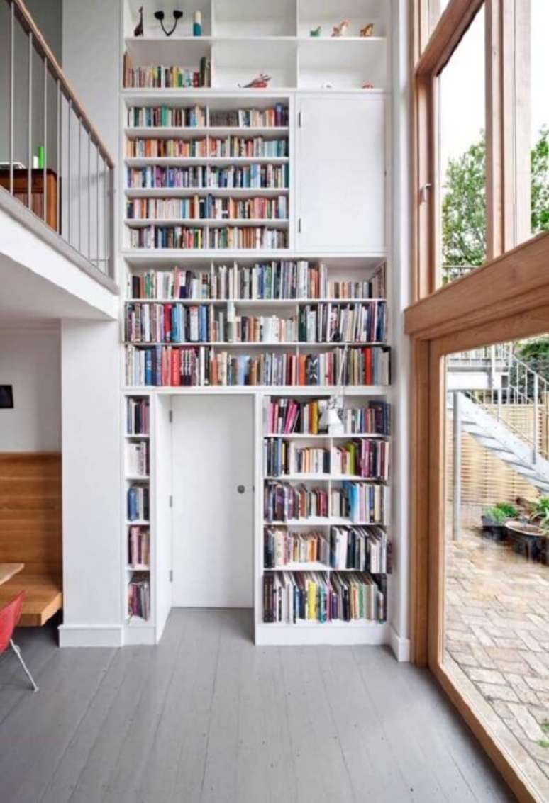 50. O espaço disponível para organização de objetos e livros se estende por toda a parede da casa com mezanino interno. Fonte: Pinterest