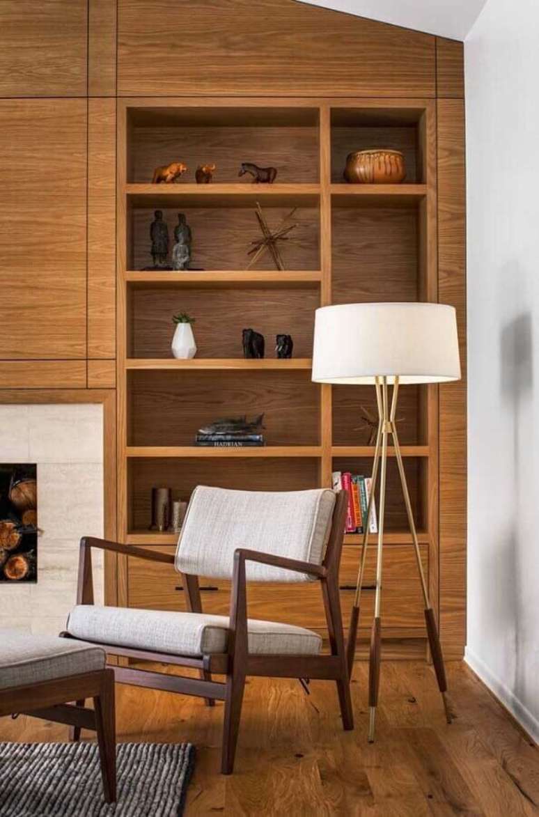 52. Poltrona pequena para leitura em sala de estar decorada com estante de madeira e abajur de chão – Foto: Richard Brown Architect