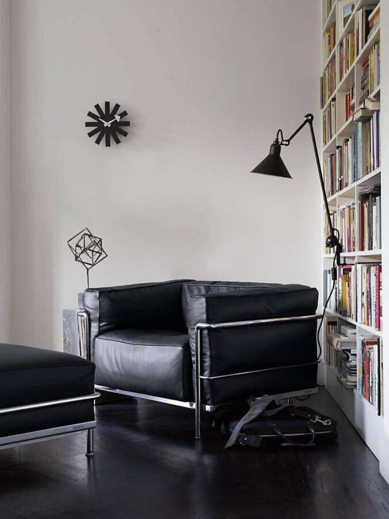 55. Cantinho de leitura decorado com estante de livros e poltrona para leitura preta moderna – Foto: Pinterest