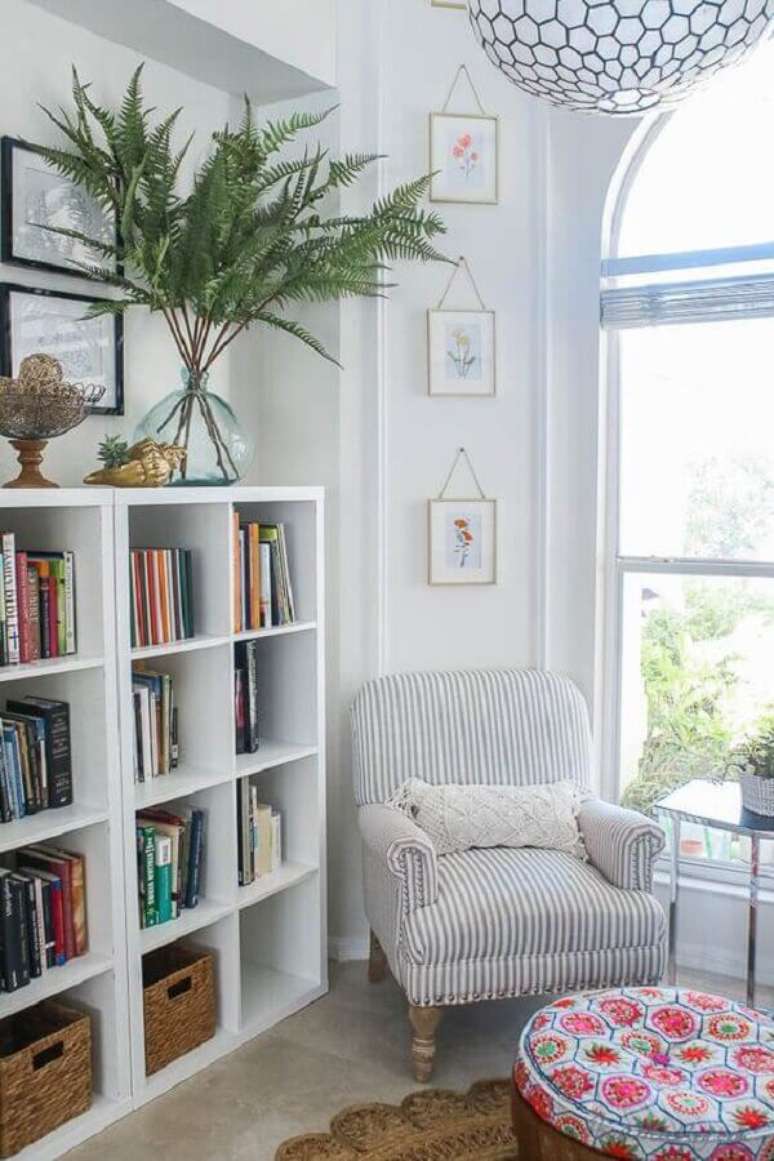 59. Sala decorada com estante branca para livros e poltrona para leitura listrada – Foto: House Mix