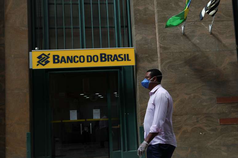 Homem usando máscara de proteção passa pela frente de agência do Banco do Brasil durante a pandemia da Covid-19. 24/3/2020. REUTERS/Amanda Perobelli