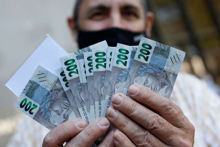 Homem segura notas de 200 reais após o lançamento da nova cédula, em Brasília
02/09/2020
REUTERS/Adriano Machado