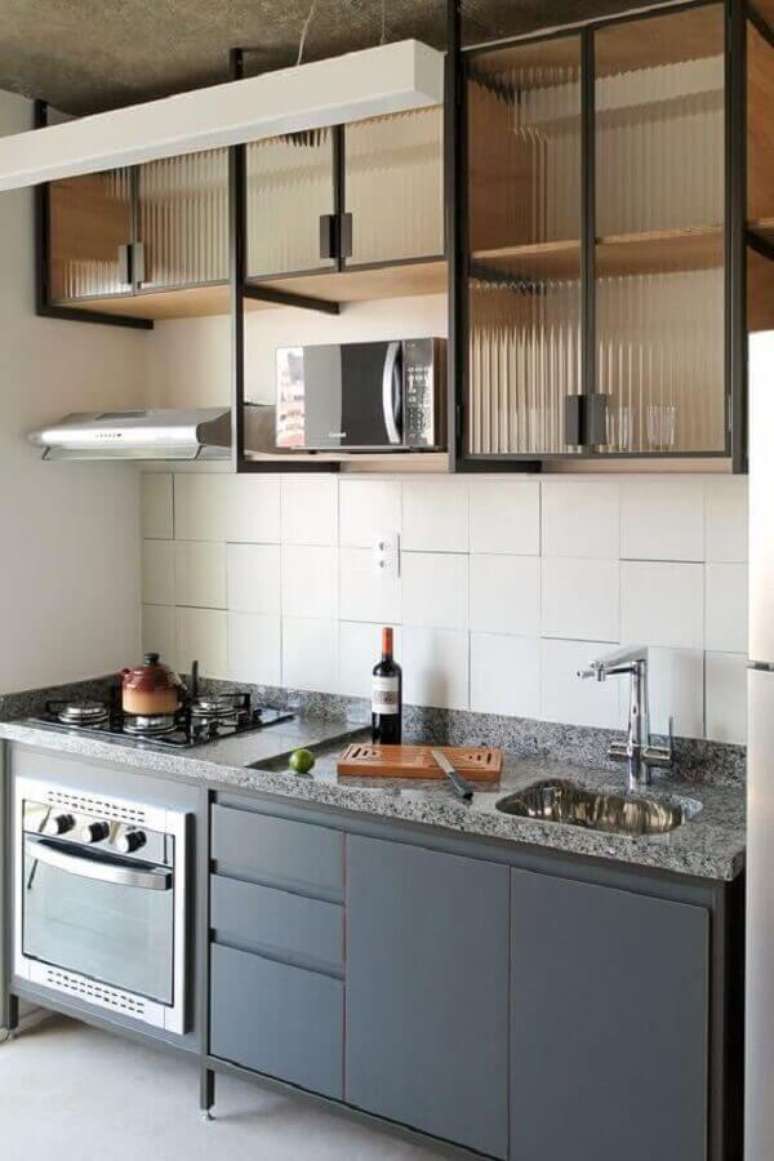 37. Decoração simples para cozinha estilo industrial pequena com armário aéreo com portas de vidro – Foto: Pinterest