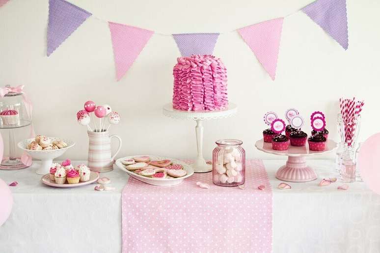 74. Festa de 15 anos simples decorada em tons de branco, lilás e rosa com bandeirinhas na parede – Foto: Punch Bowl