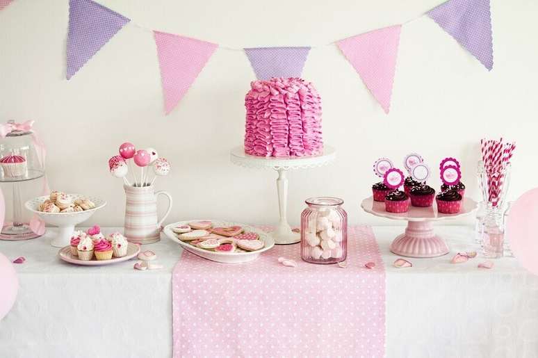 74. Festa de 15 anos simples decorada em tons de branco, lil&aacute;s e rosa com bandeirinhas na parede &ndash; Foto: Punch Bowl