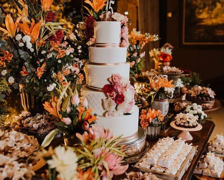 36. Em uma decora&ccedil;&atilde;o cl&aacute;ssica e sofisticada para festa de anivers&aacute;rio de 15 anos n&atilde;o pode deixar de usar muitas flores na mesa do bolo &ndash; Foto: Mara Araujo