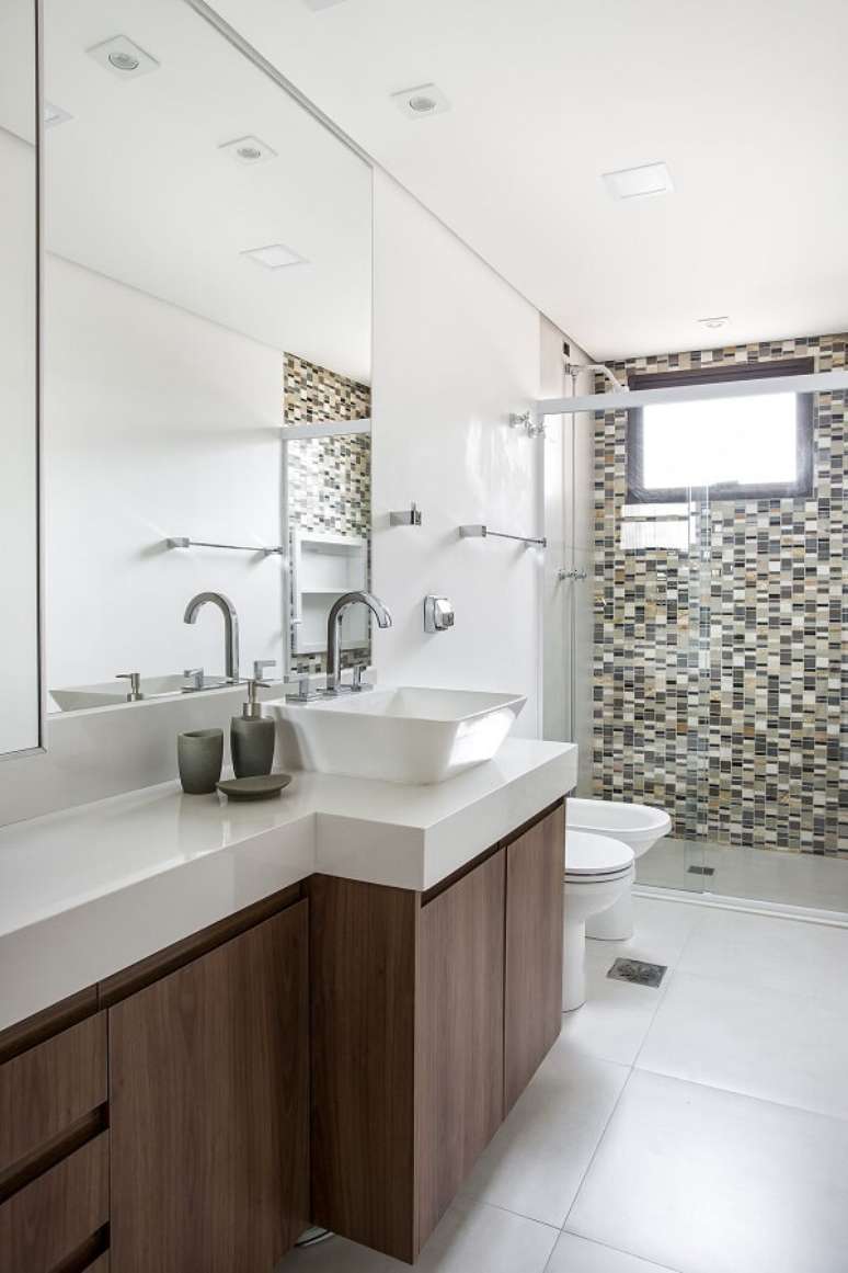 6. A cuba pia de apoio para banheiro foi posicionada sobre um gabinete amadeirado. Projeto por Lili Giudice