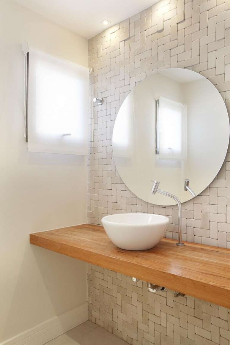 34. Cuba de apoio para banheiro oval sobre a bancada de madeira. Projeto por Leticia Ara&uacute;jo