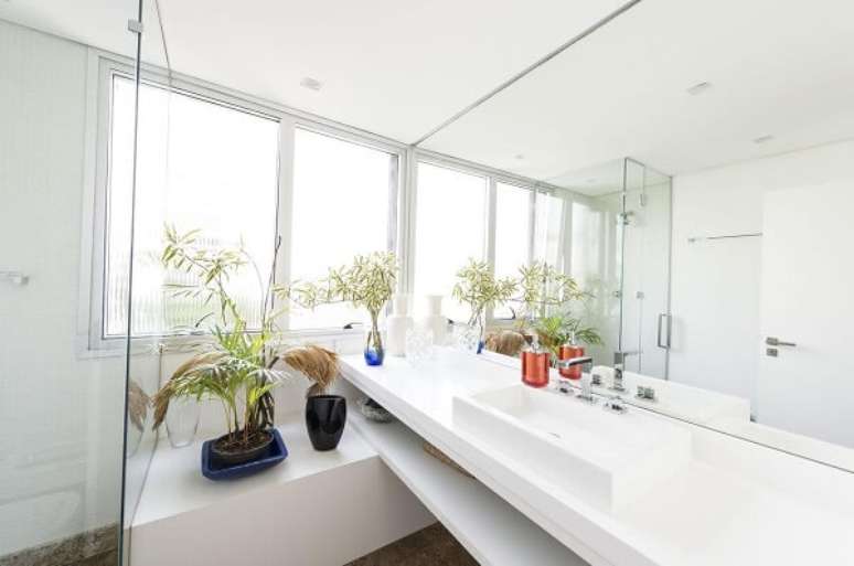 16. Os m&oacute;veis em marcenaria branca se misturam com a cuba de apoio para banheiro. Projeto por Cl&aacute;udia Lima