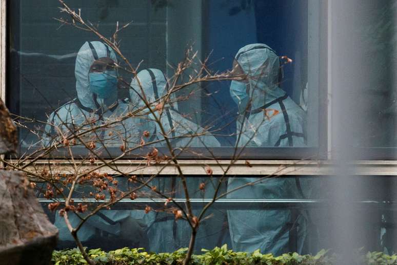 Membros de equipe da OMS em trajes de proteção durante visita a centro de prevenção de doenças animais em Wuhan, na China
04/02/2021 REUTERS/Thomas Peter