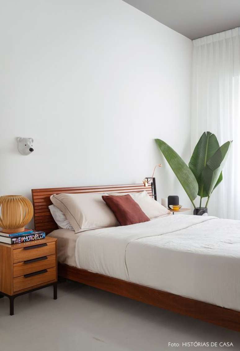 40. Cama de madeira no quarto clean decorado com plantas – Via: Histórias de Casa