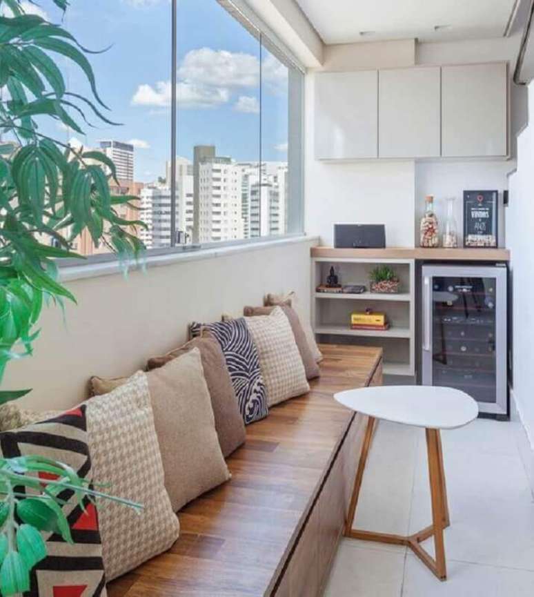 2. Decora&ccedil;&atilde;o de varanda pequena com banco de madeira decorado com almofadas &ndash; Foto: Arkpad