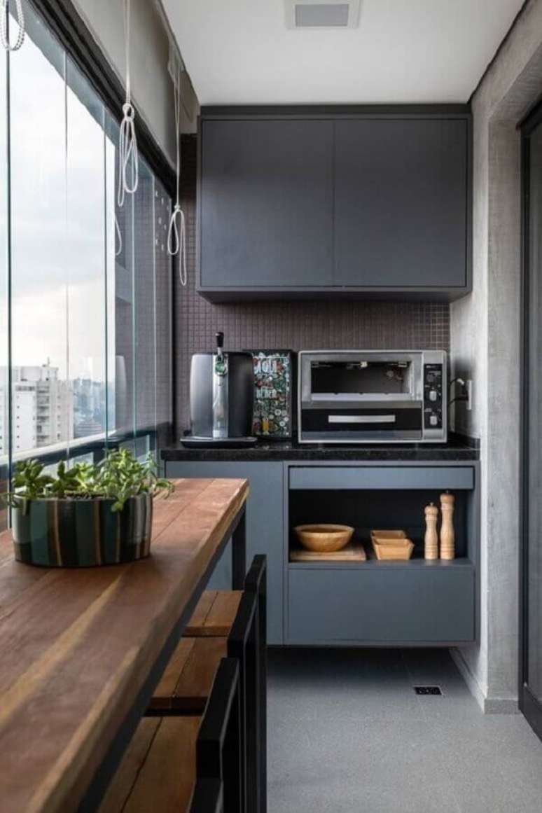 31. Móveis cinza planejados para decoração de varanda pequena e moderna com bancada de madeira – Foto: Histórias de Casa