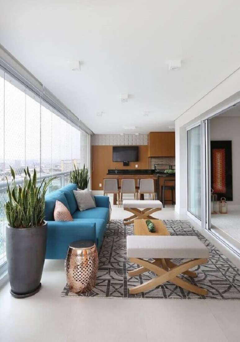 50. Sofá azul para varanda de apartamento decorada com bancada gourmet – Foto: Pinterest