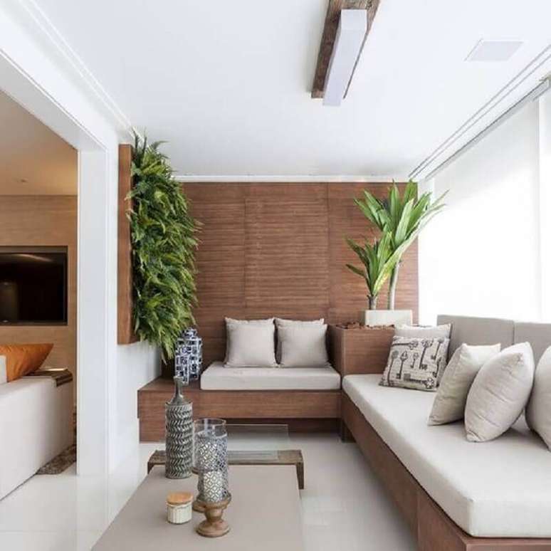51. Varanda de apartamento decorada com sofá de canto de madeira – Foto: Jeito de Casa